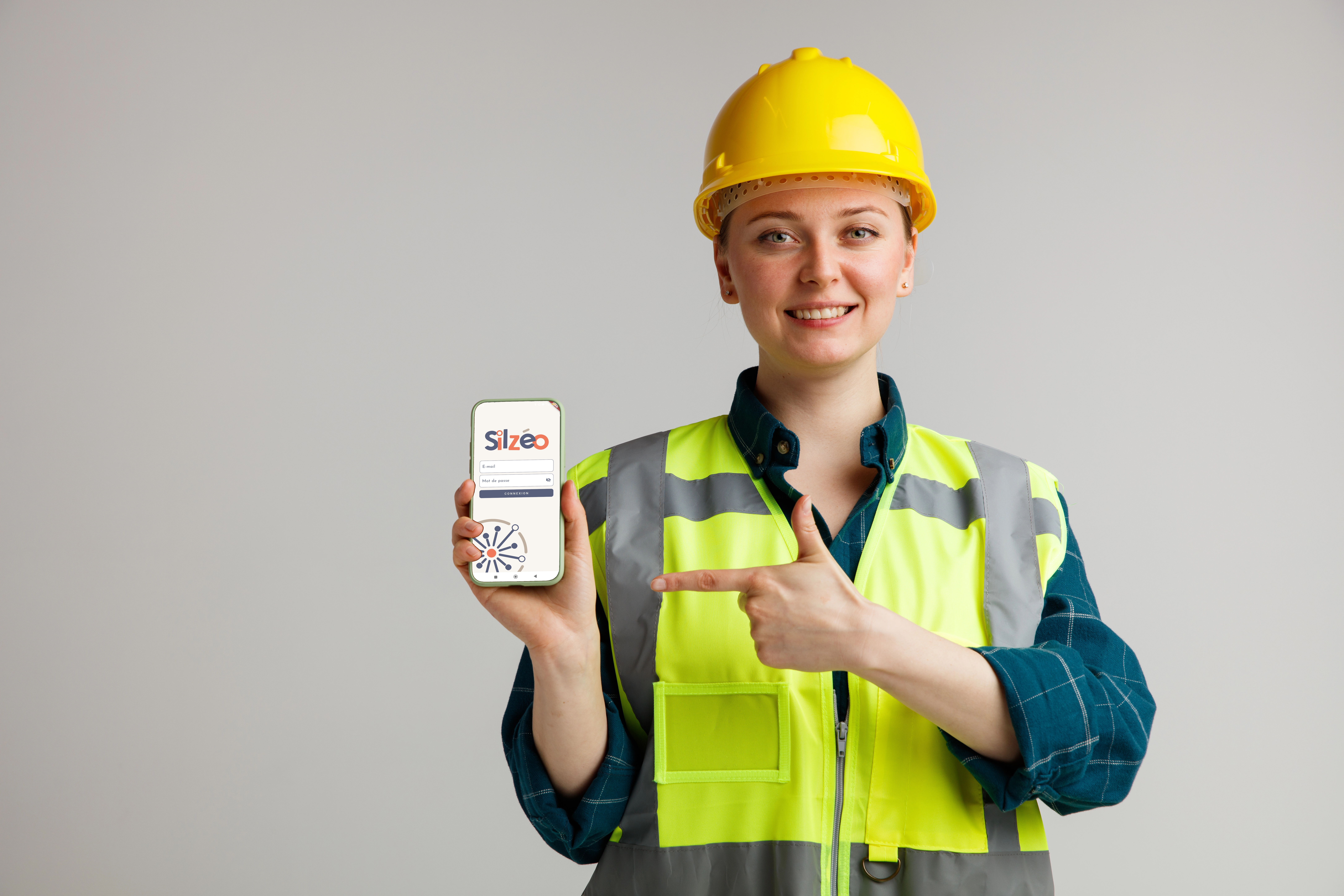 Femme de chantier avec téléphone dans la main sur appli Silzéo